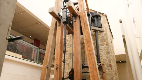 large wooden structure inside museum with visitors