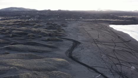 桑德維克黑火山海灘在日出時有摩托車輪胎痕跡,空中