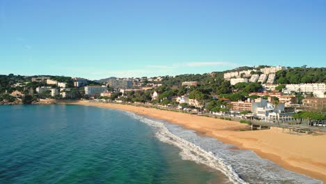 waves gently rolling onto the golden sand of beach in platja de sant pol , spain