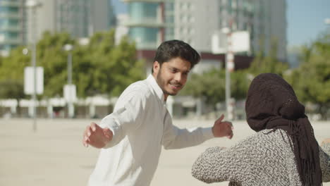 young muslim couple having fun dancing outside.