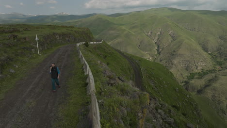 Travel-Photographer-Walking-On-Mountain-Pass-Carrying-Camera-On-His-Shoulder-Near-Borjomi-In-Georgia