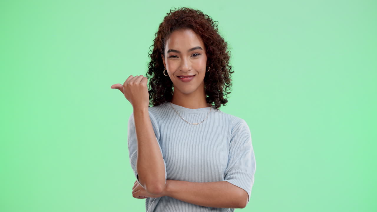 A woman pointing to the side in a studio shot