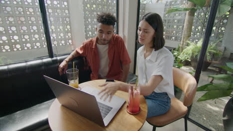 business partners using laptop while catching up in cafe