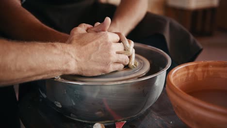 viejo tipo experimentado enseñar al hombre cómo usar la rueda de alfarero para crear producto de arcilla hecho a mano