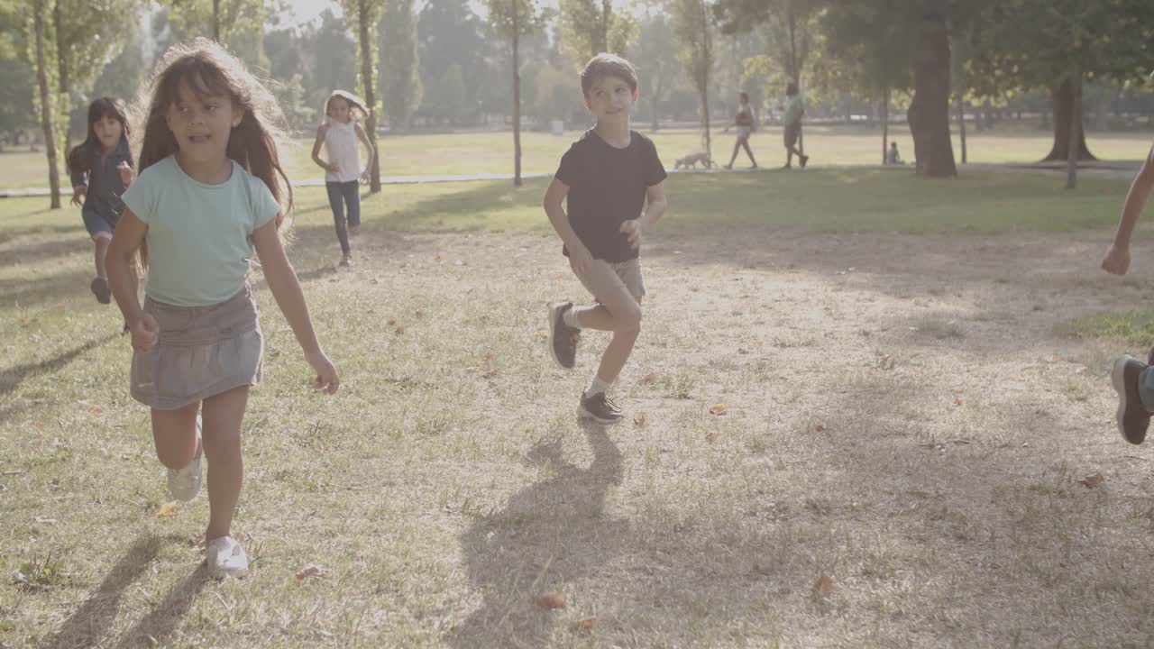 alegres niños multiétnicos corriendo juntos en el parque