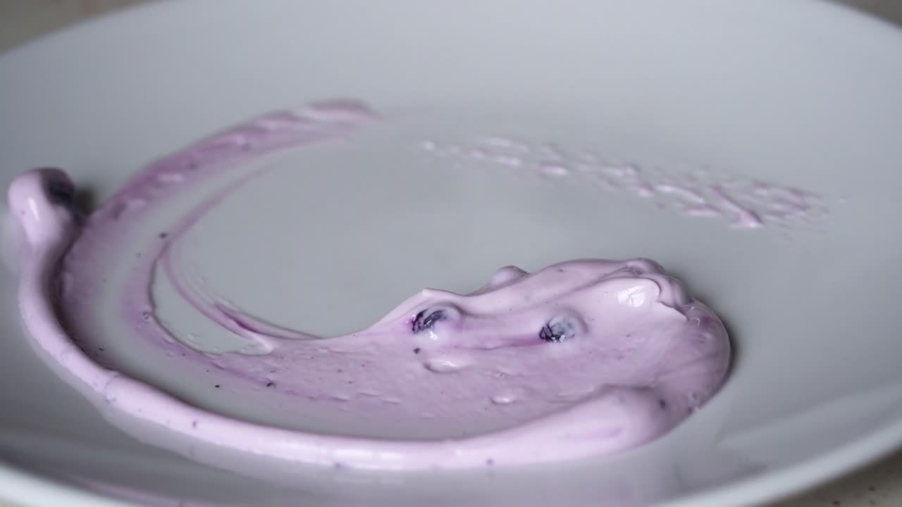 보라색 크림 소스로 접시를 장식하고 그 위에 롤 크레이프를 얹는 셰프