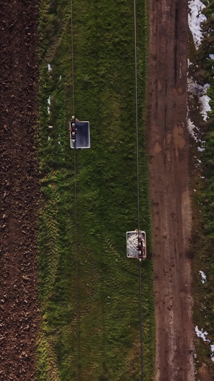 Landbrugsjord med grusvej og landbrugsudstyr på åbent område om dagen