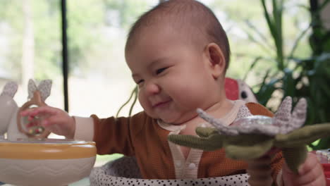 baby playing with toys and chewing activity center