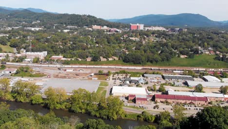 video aéreo de drones de 4k del patio de trenes del sur de norfolk y el distrito de artes fluviales a lo largo del amplio río francés en asheville, nc