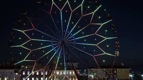 ferris wheel with glowing multicolored lights against the night sky.