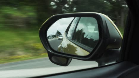 blind spot view on the side mirror of a car while driving on the road