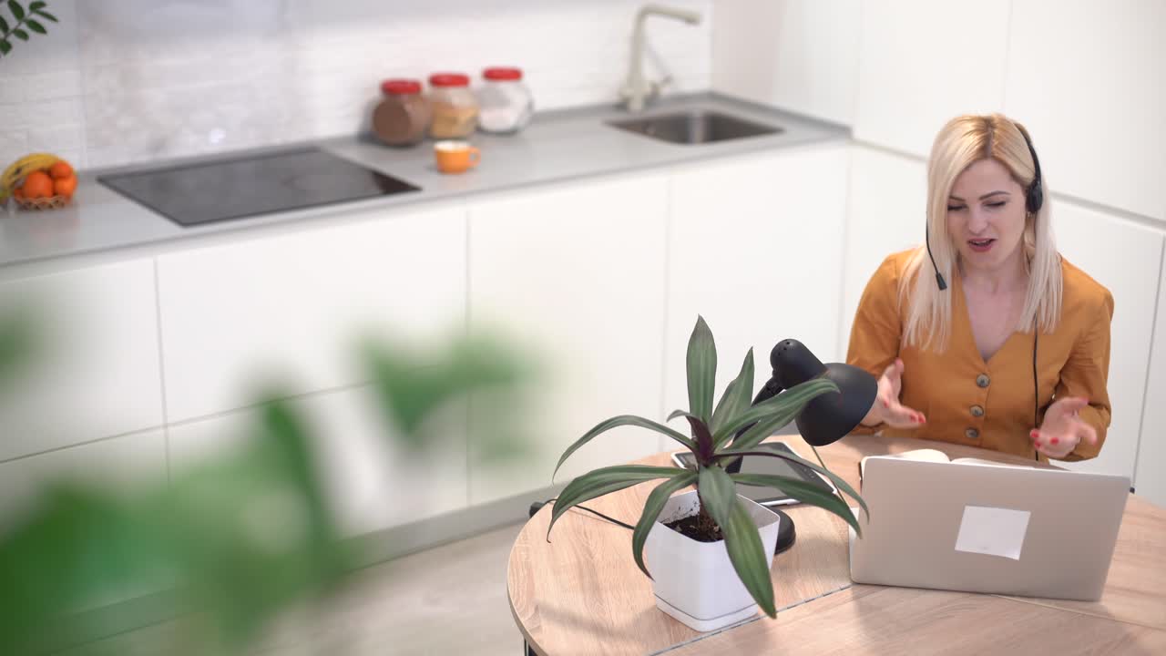 mujer trabajando con una computadora portátil en una cocina brillante. covid-19 coronavirus. distanciamiento social