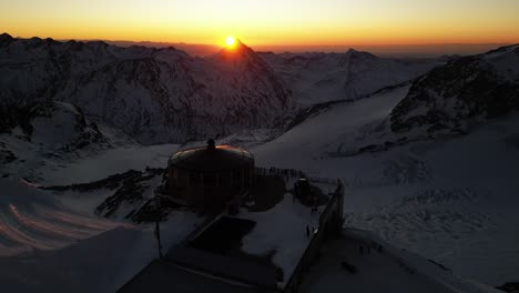 aerial panning shot: mountain range on the horizon, sunrise with an orange sky