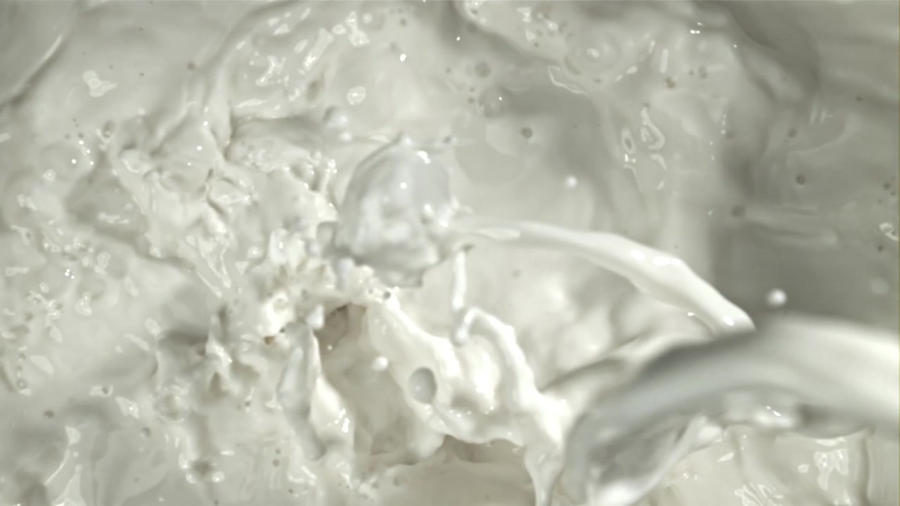 Liquido bianco che si versa e schizza al rallentatore.