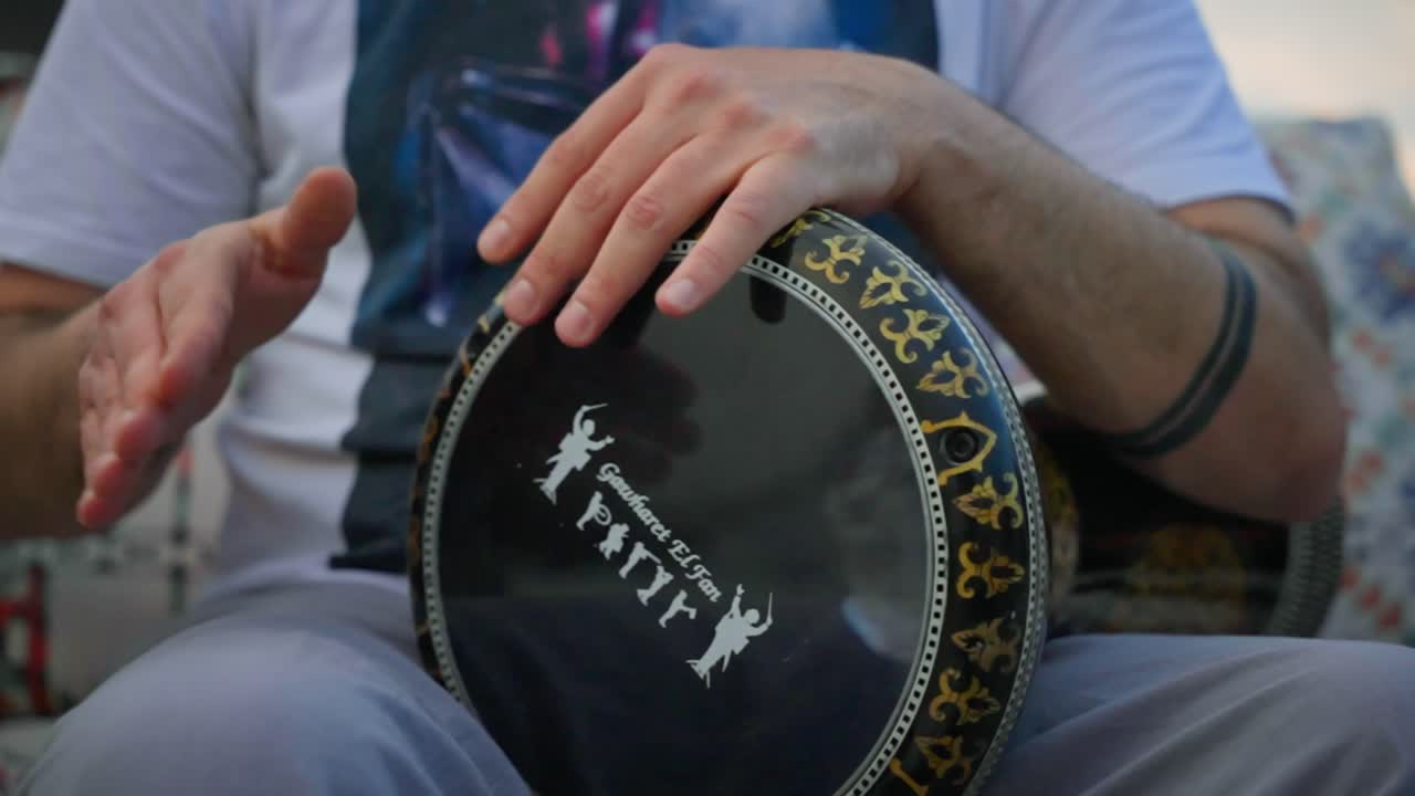 primer plano de un tipo en un tambor árabe, tocando la darbuka con vibraciones orientales