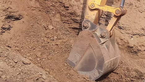 an excavator loads moorum soil into a tractor at construction land