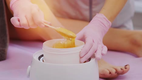 liquid sugar for skin epilation. close up shot. depilation and beauty concept - sugar paste or wax honey for hair removing with wooden waxing spatula sticks