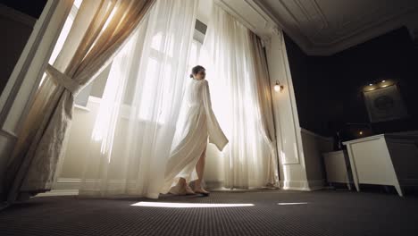 Bride-in-boudoir-dress-near-window,-wedding-morning-preparations,-woman-in-night-gown-and-veil