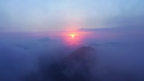 Drone-Volando-Directamente-Al-Sol-Dorado-A-Través-De-Una-Espesa-Nube-Rosa-Al-Atardecer-O-Al-Amanecer