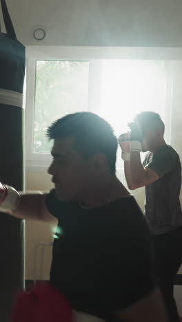 el equipo de kickboxer hace ejercicios con equipos en el gimnasio. los estudiantes de artes marciales hacen golpes con las piernas y los brazos en el club deportivo en cámara lenta. actividad saludable