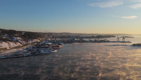 golden hour sunset light over port near bjorvika, oslo with fog floating above water