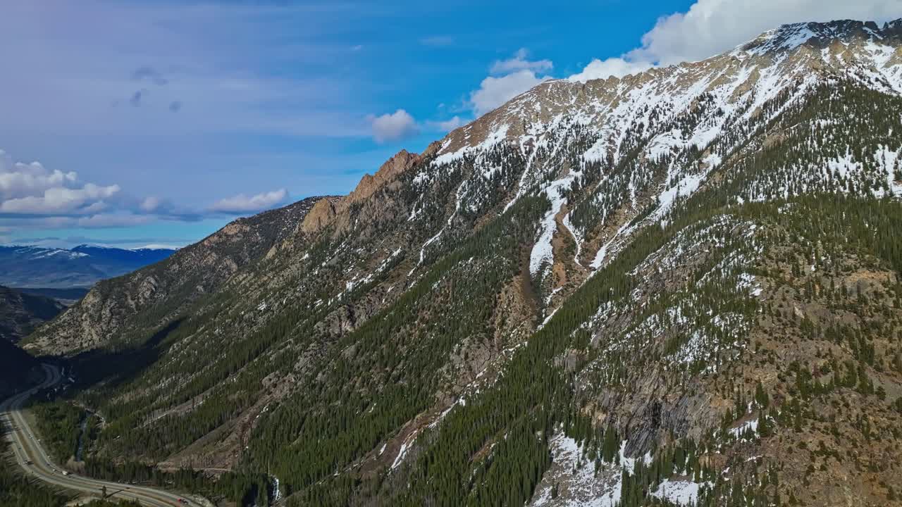 High altitude drone establishing of snow covered Frisco Gulch ridges and evergreen forest, Colorado USA