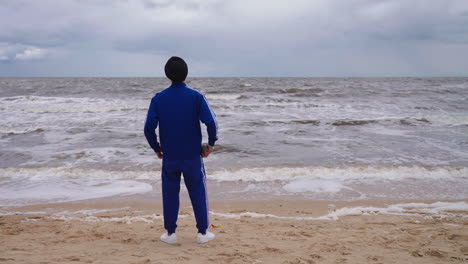 punjabi sikh man at the beach with rough waves onto shore