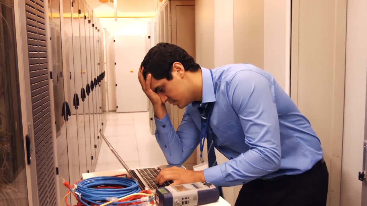 técnico estresado usando una computadora portátil
