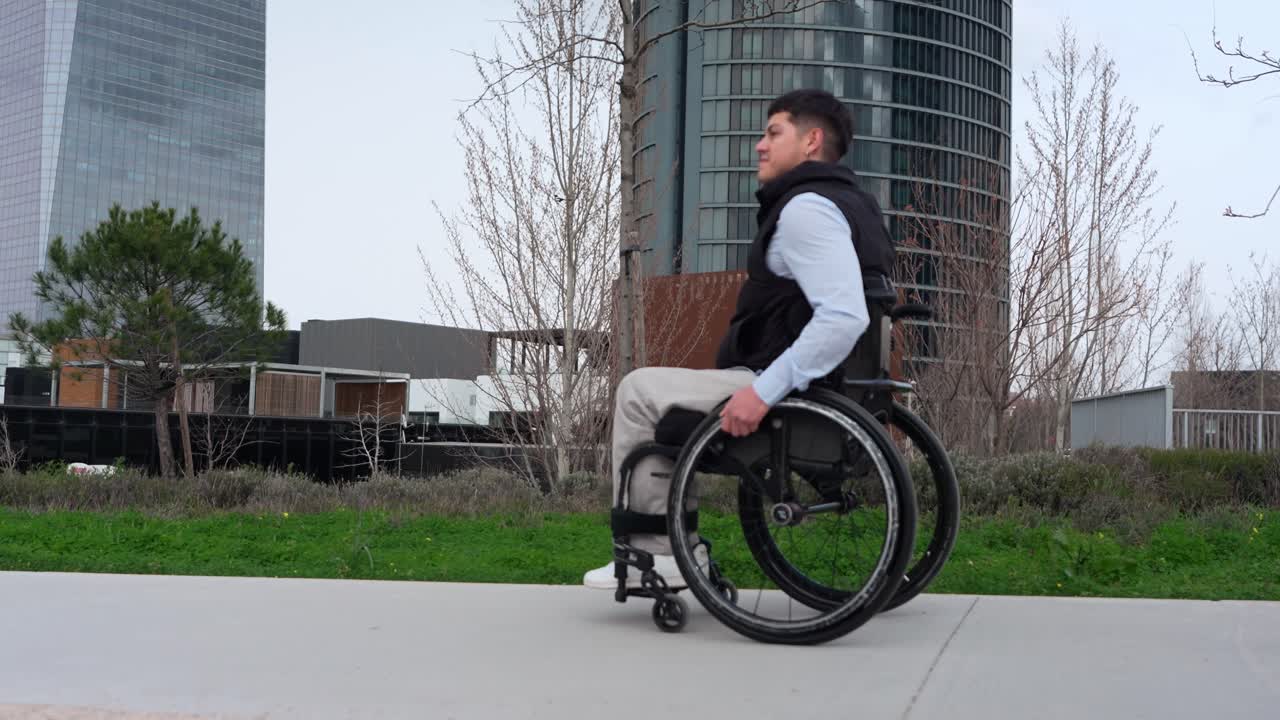 Young Man in Wheelchair Moving Along Urban Pathway
