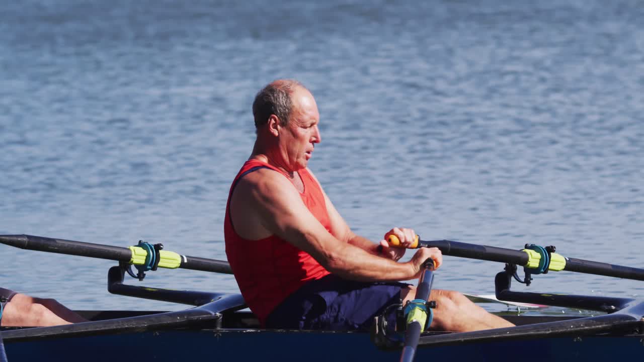 Two senior caucasian men rowing boat on a river