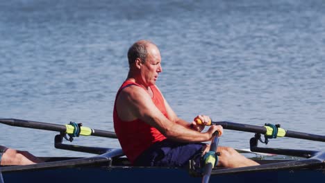 Two-senior-caucasian-men-rowing-boat-on-a-river