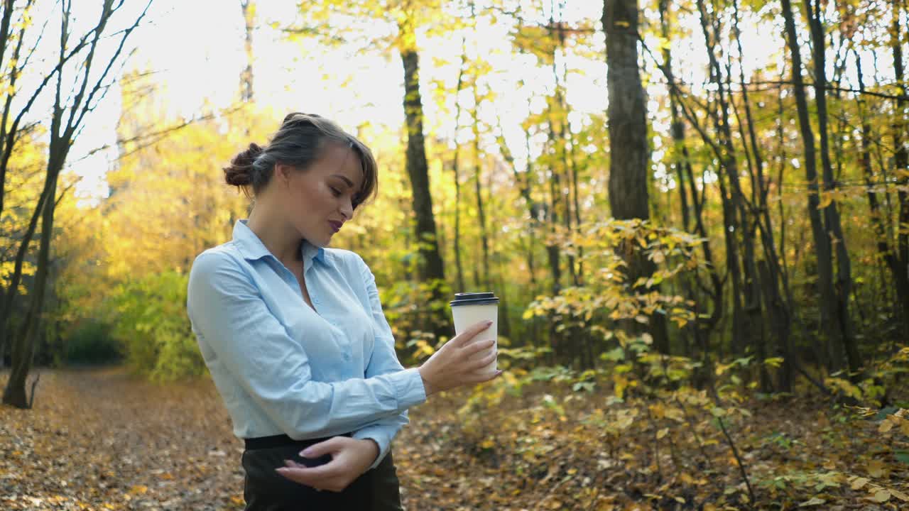 Woman drinking hot tea. Woman warm up with hot tea in autumn park