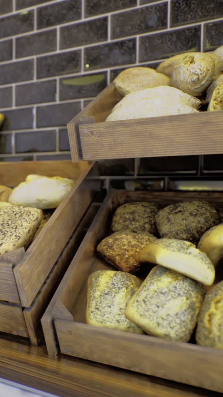 Breads displayed on wooden shelves in a bakery during daytime in the city