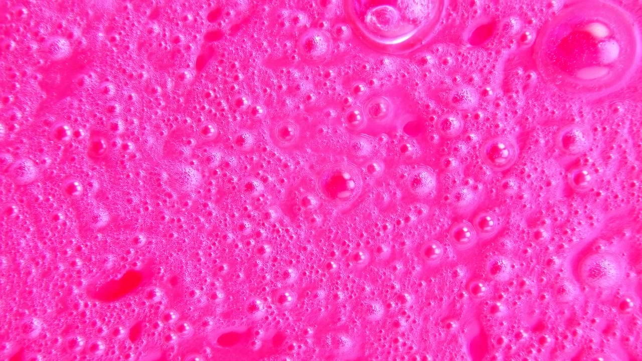 Questo video mostra un primo piano di una superficie rosa testurizzata vista al microscopio, offrendo uno sguardo dettagliato ai suoi intricati motivi e alla sua palette di colori neutri. Elementi di design.