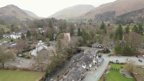 Approaching-drone-shot-of-Grasmere,-a-village-by-the-lake-in-Cumbria-at-Westmorland-and-Furness,-located-in-Northwest-England,-United-Kingdom