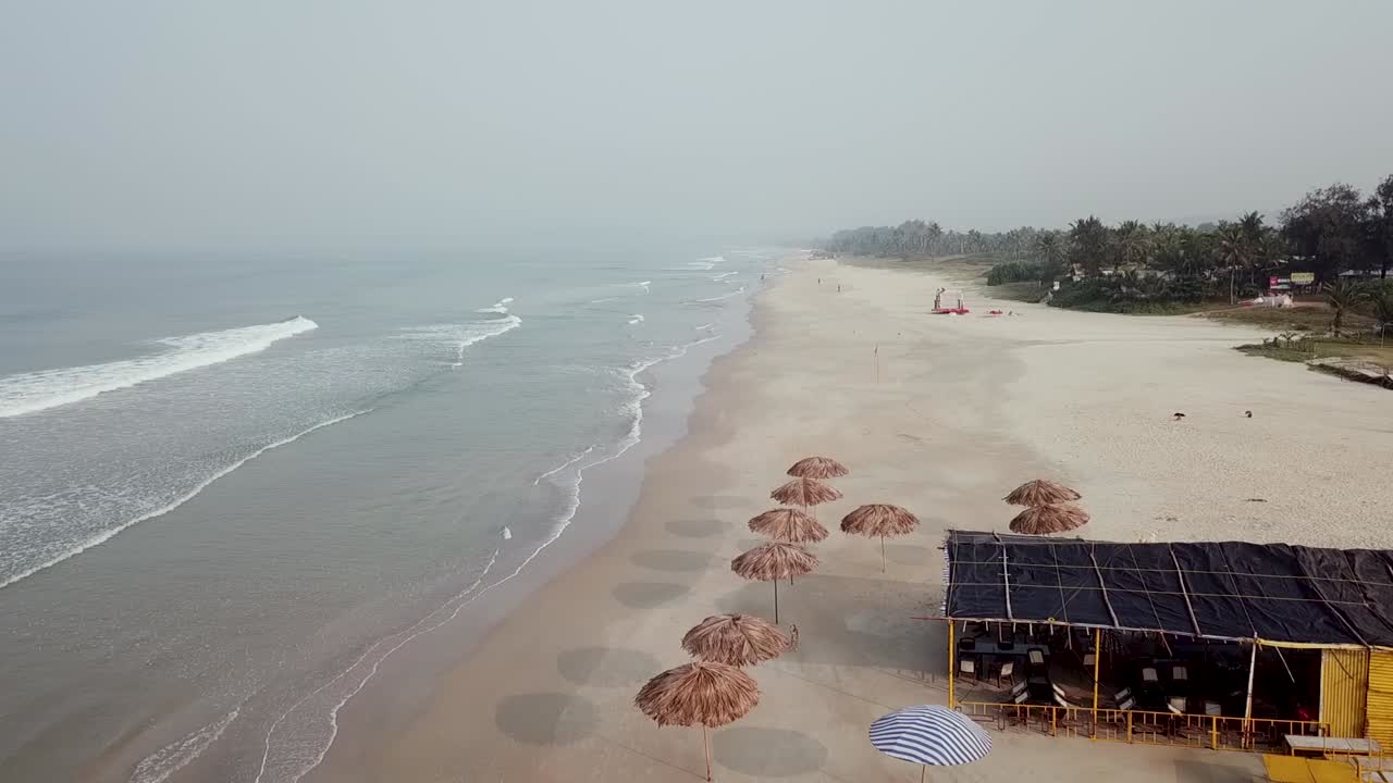A Drone shot over a beautiful sea heading towards the trees, Goa, India