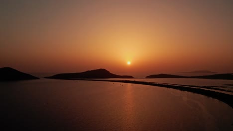 Ball-of-sun-spreads-misty-hazey-light-through-sky-above-calm-ocean-bay-on-pylos-island