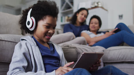 mixed race girl using a digital tablet with headphones on