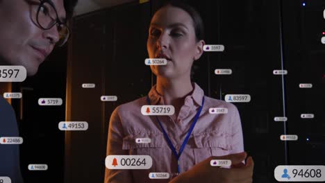 Animation-Von-Social-Media-Symbolen-über-Verschiedene-Männliche-Und-Weibliche-IT-Ingenieure-Durch-Computerserver