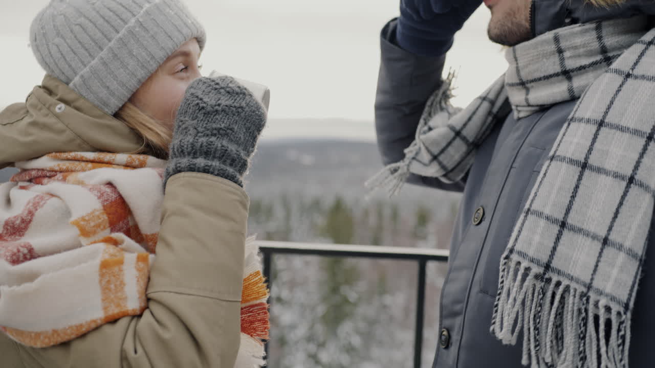 Couple enjoying a hot drink in the winter mountains