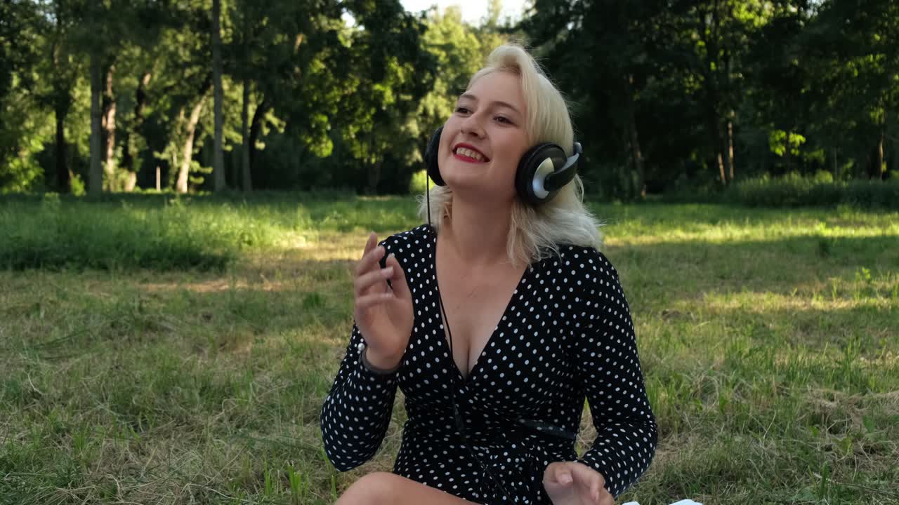 어린 소녀는 헤드폰을 끼고 음악을 듣는다