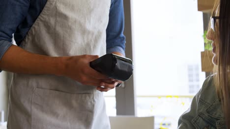 camarero que acepta el pago por teléfono móvil 4k
