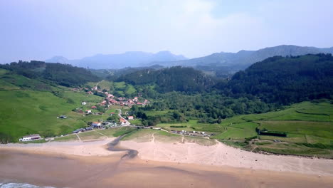 aerial view of a coastal village and beach with mountains