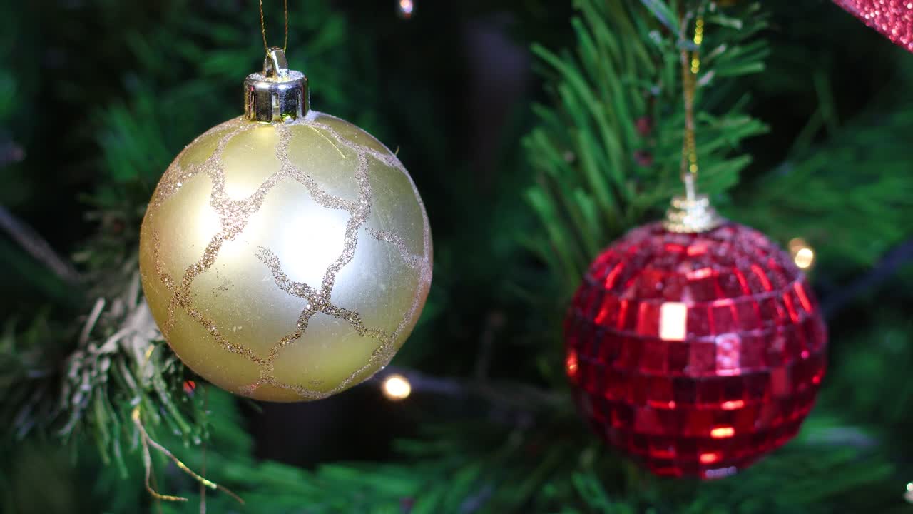 adornos de navidad dorados y rojos en el árbol de navidad con luces parpadeantes