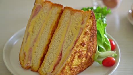 Sándwich de jamón y queso casero en la placa blanca.