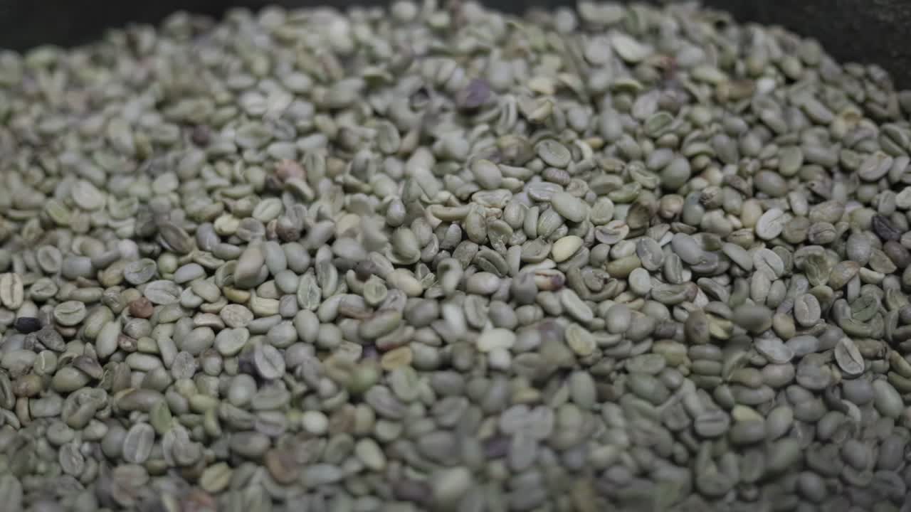 coffee beans falling in slow motion onto many other beans