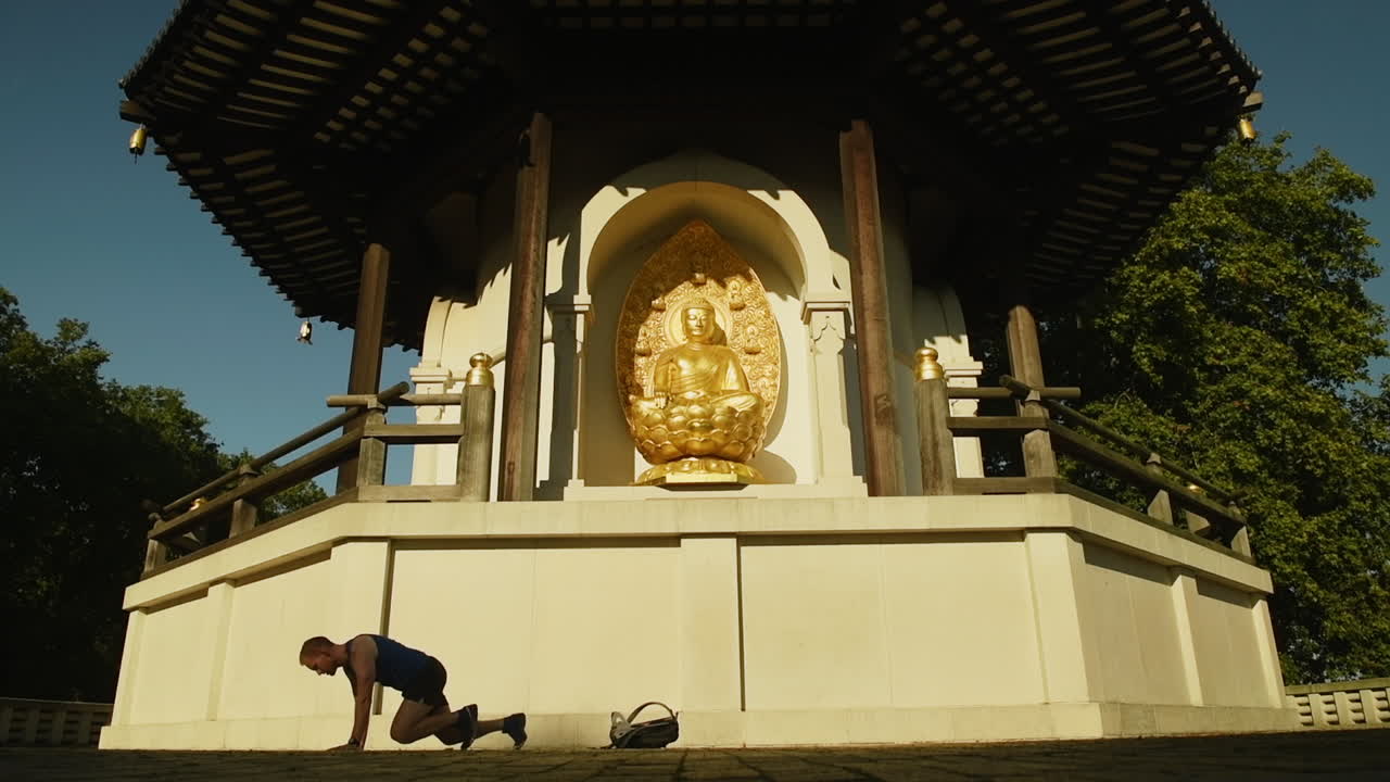 Man stretching his core and legs before running in a park in London, Peace Pagoda