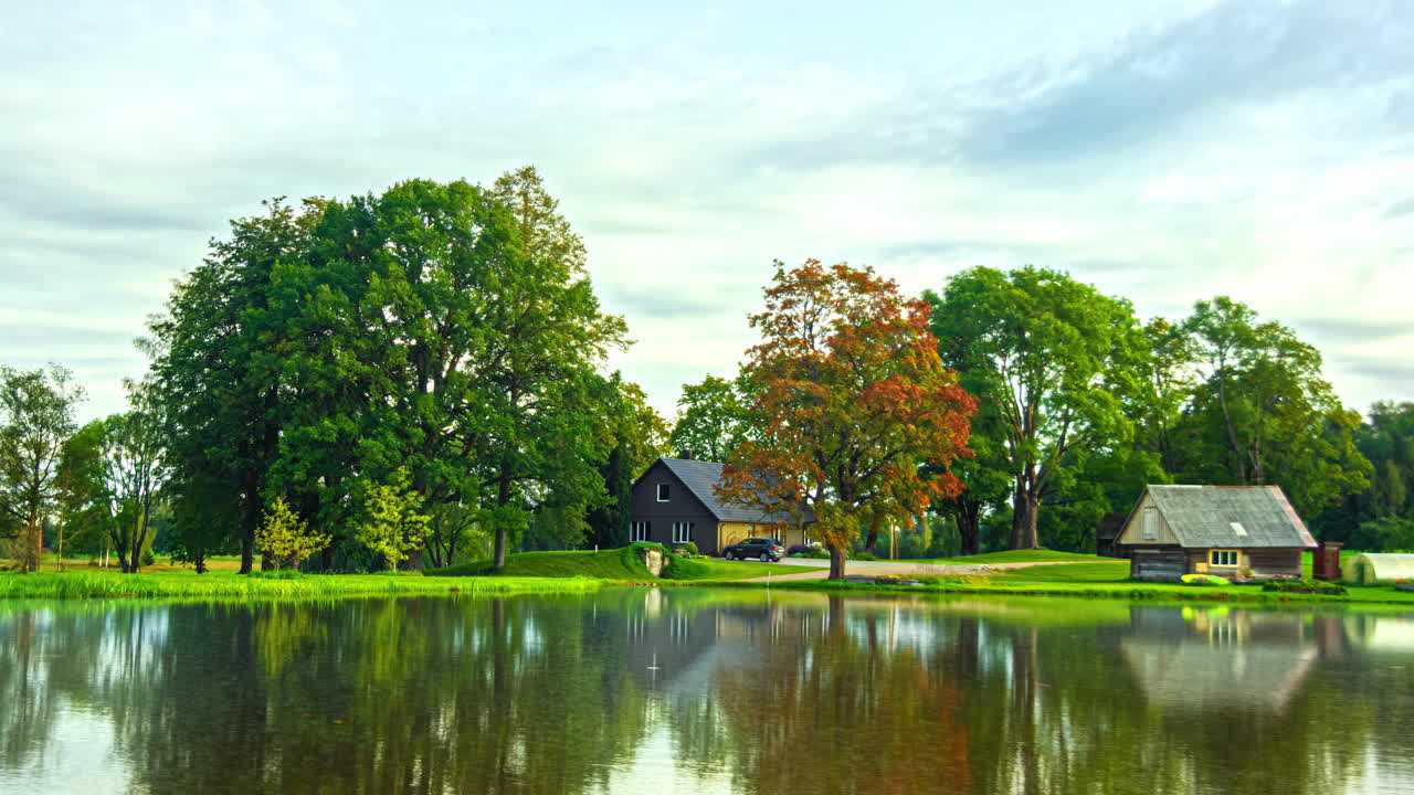 Timelapse over dam with trees shows changing of four seasons in countryside