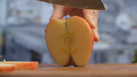 cortar un cuchillo en una tabla de madera de primer plano manzana roja en la cocina. triturar