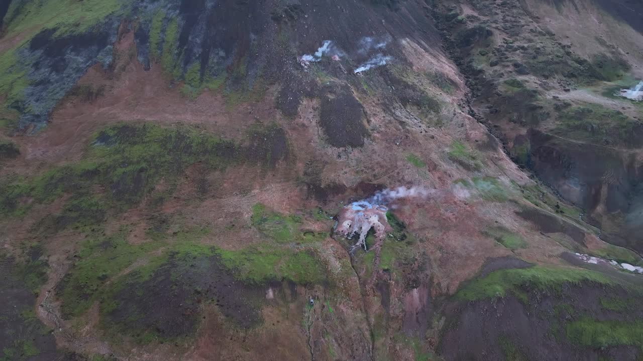 aguas termales con vapor en las colinas al lado de la ciudad de hveragerdi en el sur de islandia - toma aérea de drones